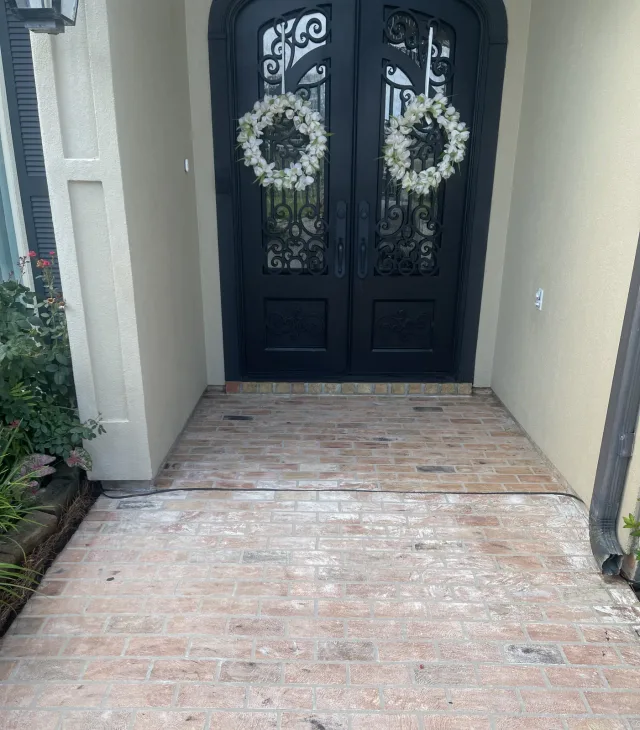 Faded brick-pattern entry at the same arched doors before the refresh.