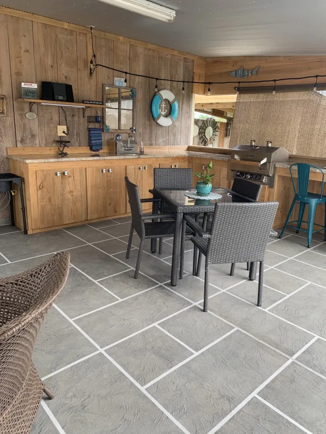 Gray tile-pattern overlay in an outdoor kitchen by Decorative Concrete of South Louisiana.