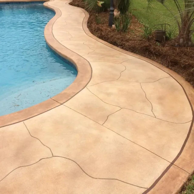 Knockdown pool deck with stained border by Decorative Concrete of South Louisiana.