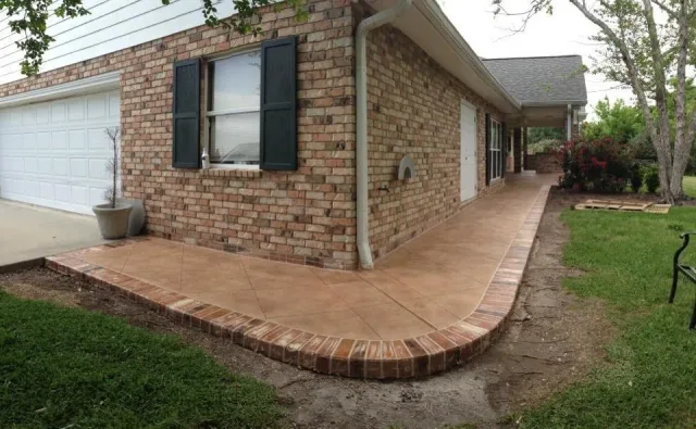 Textured walkway with brick border by Decorative Concrete of South Louisiana.