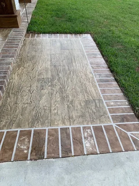 Wood-plank overlay with brick border by Decorative Concrete of South Louisiana.