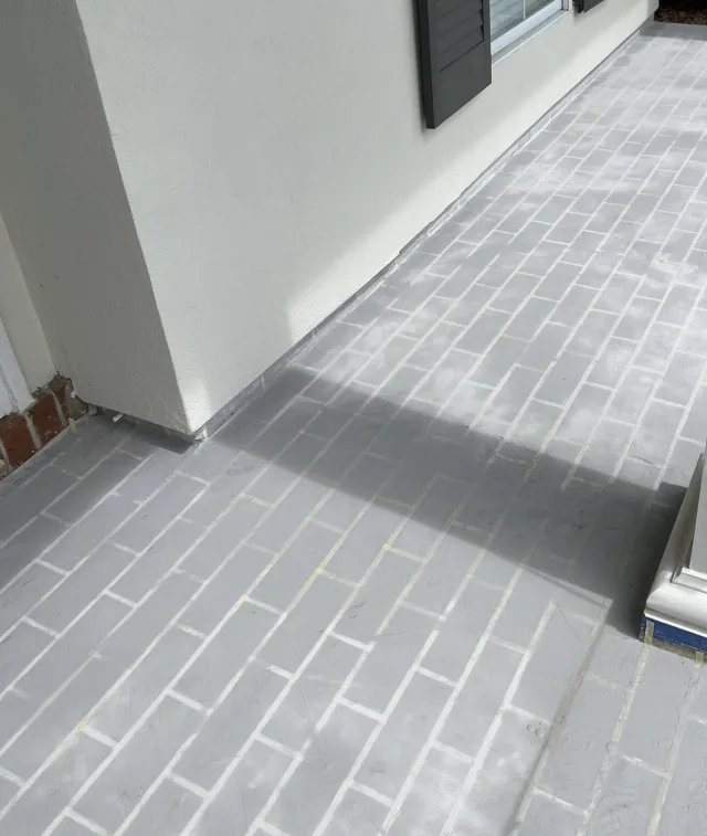 Gray pattern-stage surface along the same porch during the overlay work.