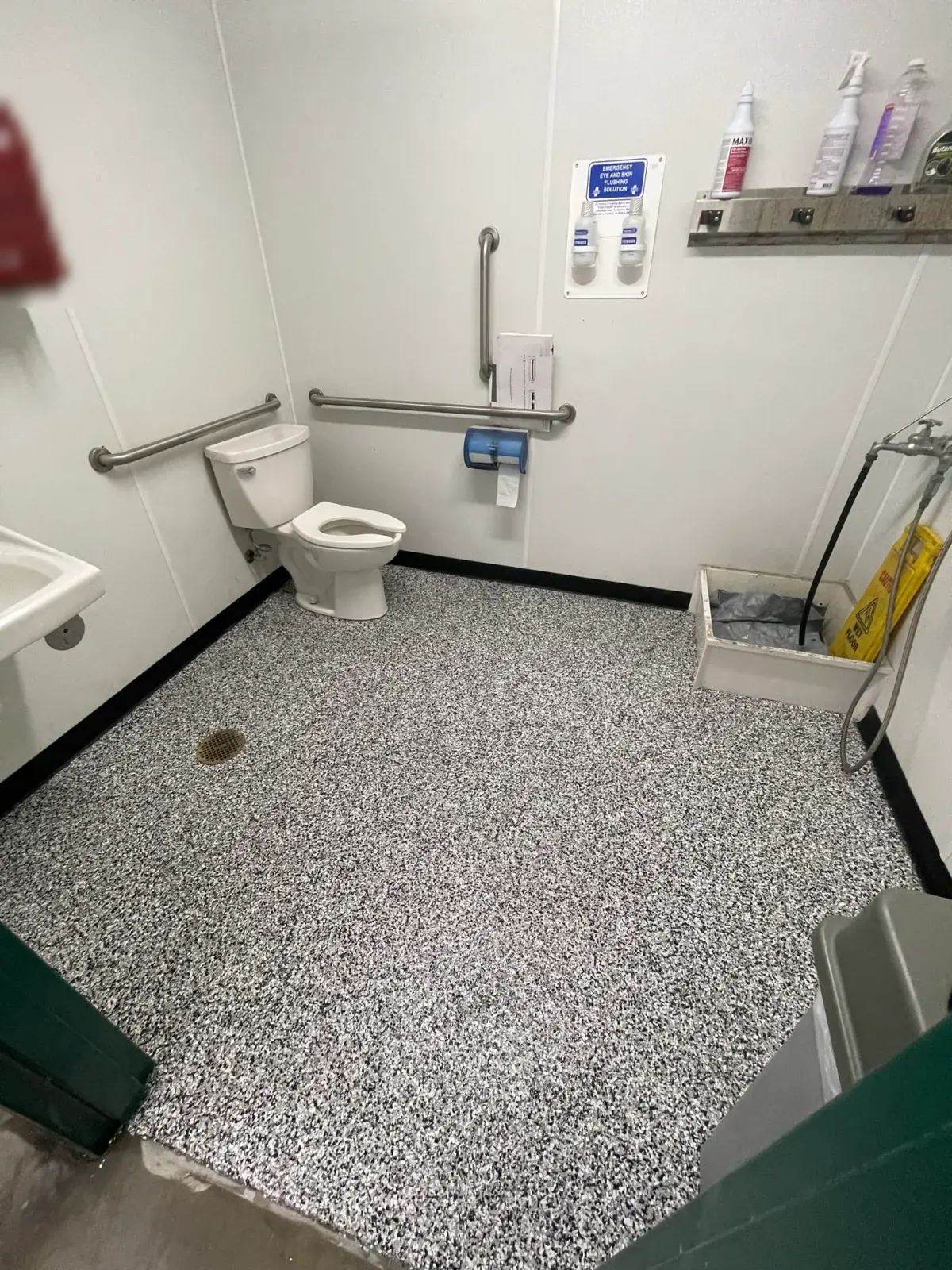 Commercial utility bathroom: Finished black-and-white flake floor