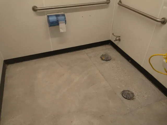 Exposed floor substrate with protected drains during the bathroom project.