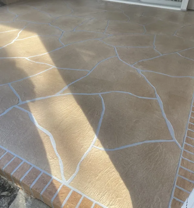 Flagstone patio with brick border by Decorative Concrete of South Louisiana.