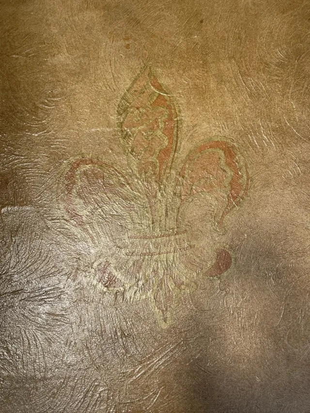 Close view of the stained fleur-de-lis medallion in the textured overlay.