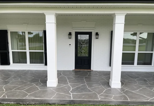 Gray flagstone-style front porch by Decorative Concrete of South Louisiana.