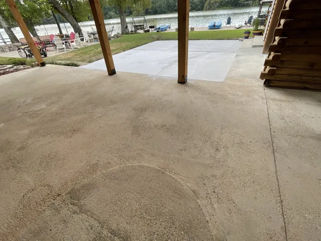 Plain gray concrete patio under the house before the overlay.