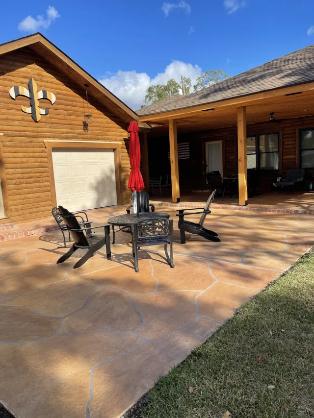 The same warm flagstone-style patio beneath the timber house beside the garage.