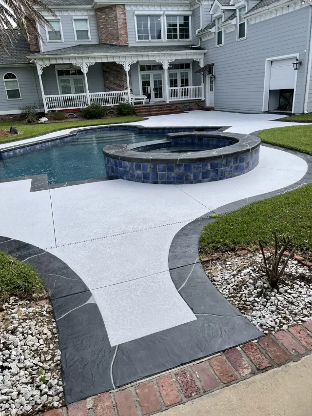 Pool deck with dark coping by Decorative Concrete of South Louisiana.