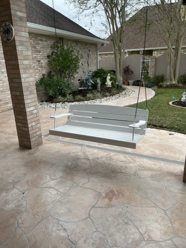 The same restored walkway beside the covered patio and white garden swing.