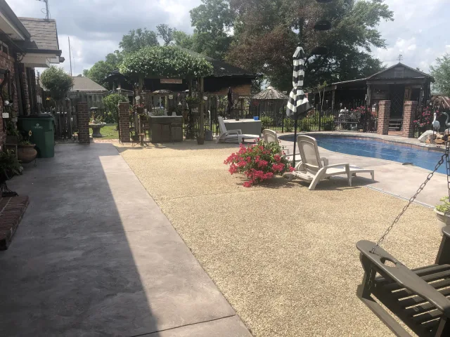 Pool deck with a warm curved border by Decorative Concrete of South Louisiana.