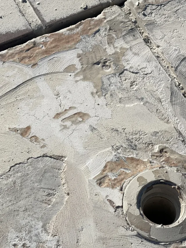 Rough prepared deck around an open drain during the work.