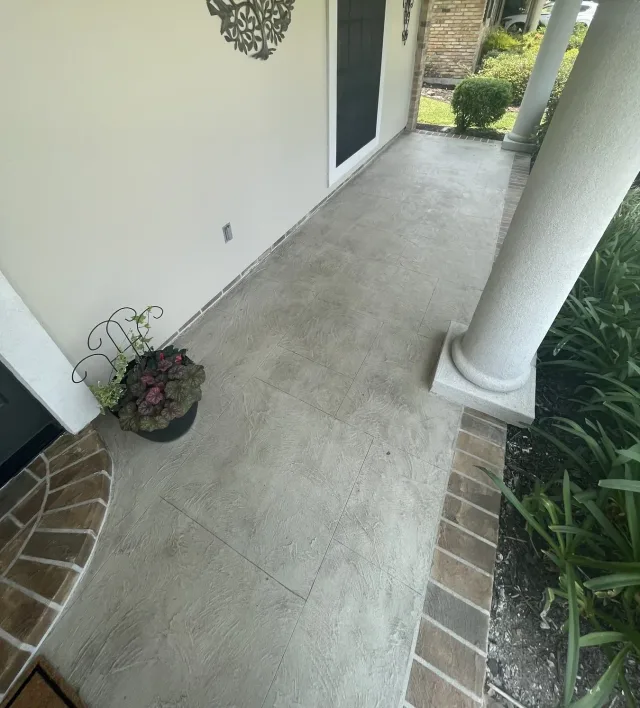 Tile-pattern front porch with brick border by Decorative Concrete of South Louisiana.