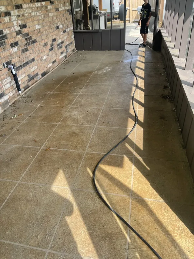 Tile-pattern porch surface being washed down during the work.