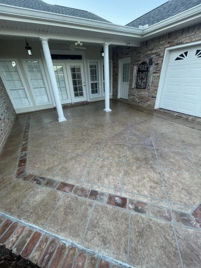 Warm courtyard with white columns by Decorative Concrete of South Louisiana.