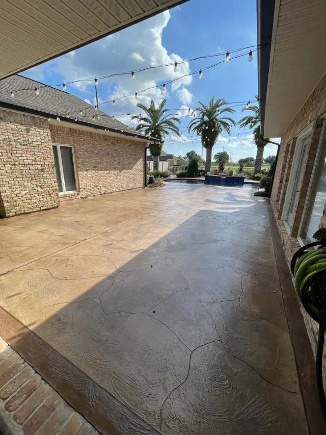 Warm flagstone-style brick courtyard by Decorative Concrete of South Louisiana.