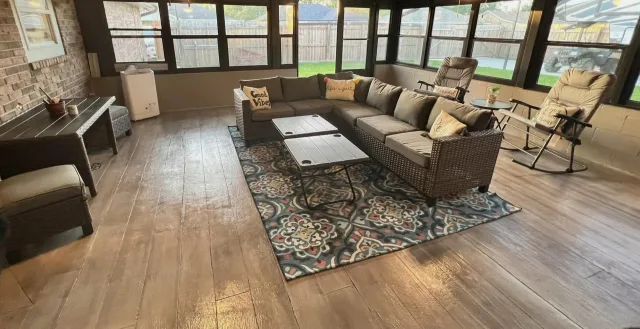 Finished wood-look concrete floor in a furnished sunroom.