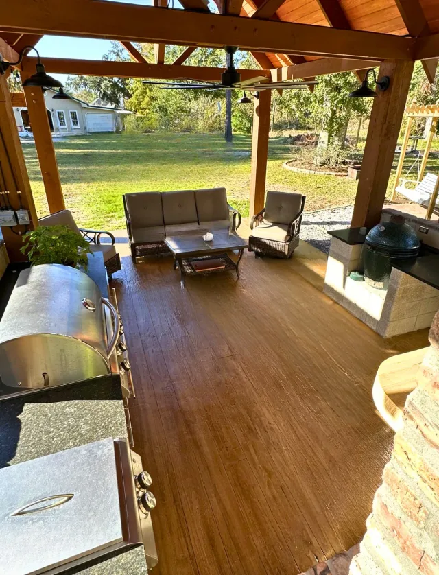 Wood-look overlay for an outdoor kitchen by Decorative Concrete of South Louisiana.