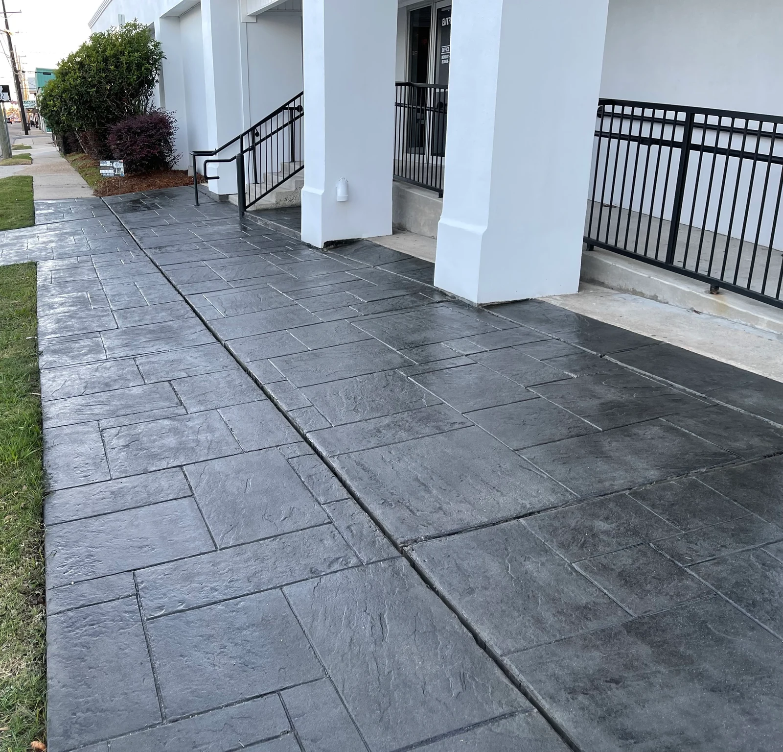 Restored slate-pattern concrete at a commercial building entrance.